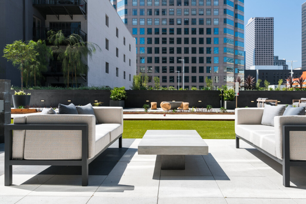 Exterior of rooftop seating area with modern couches and grass in the background