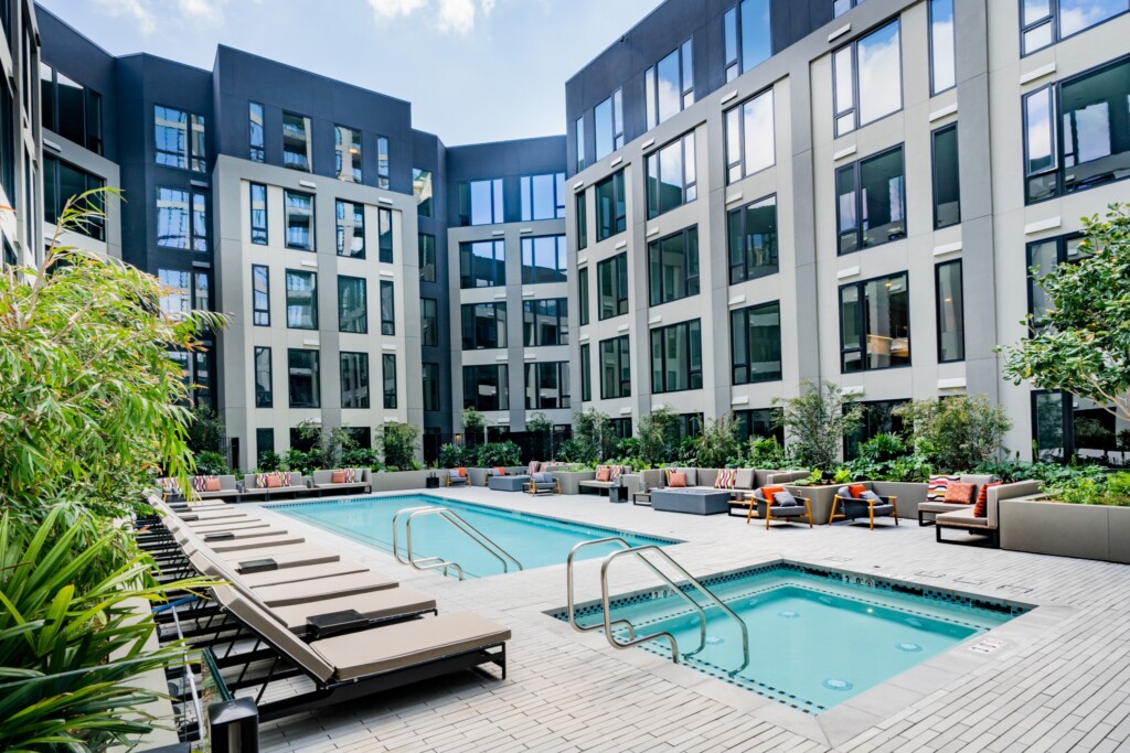 Exterior of swimming pool and spa surrounded by modern lounge chairs in a courtyard