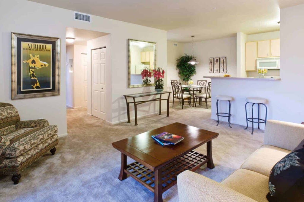 Interior of apartment living room with open kitchen and dining area.