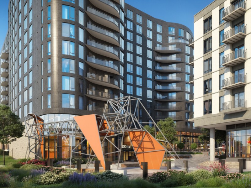 Exterior of 12-story curved wall apartment building and smaller 6-story apartment building with modern geometric sculpture in foreground
