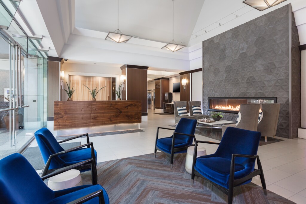 Lobby reception areas with chairs, coffee table and a long gas fireplace.