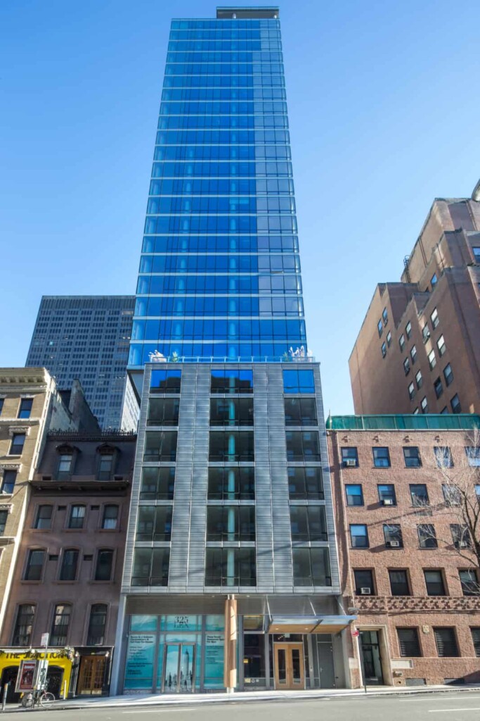 Street-level view up the glass-walled apartment tower.