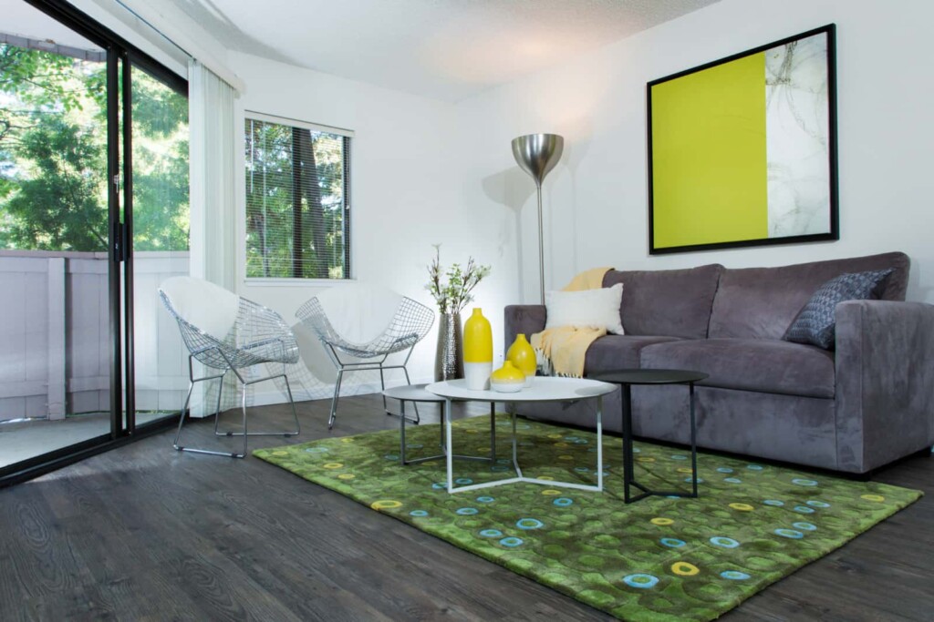 Bright apartment living room with sliding glass doors onto exterior balcony.