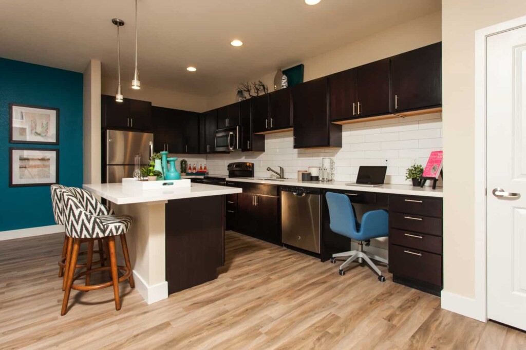 Open kitchen with center island, white counter tops and dark cabinets.