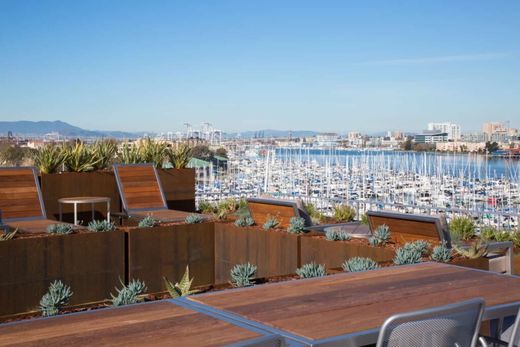 Rooftop lounges, table and chairs with marina view in background.