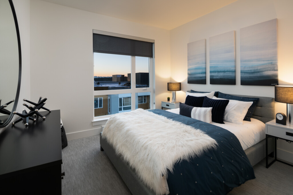 Interior of apartment bedroom with modern furnishings and large window