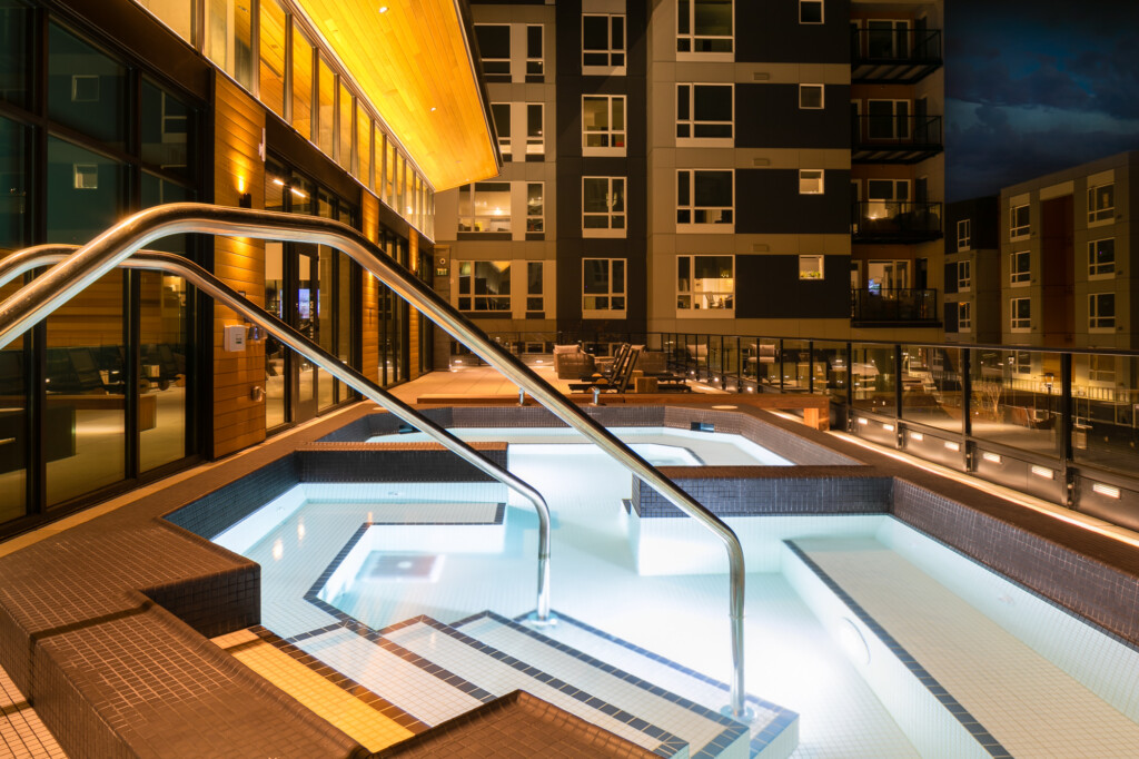 Exterior of large tiled spa pool with apartment complex in background