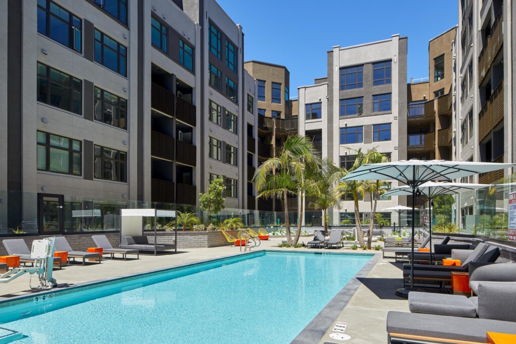 Exterior of swimming pool, lounge chairs, umbrellas in courtyard