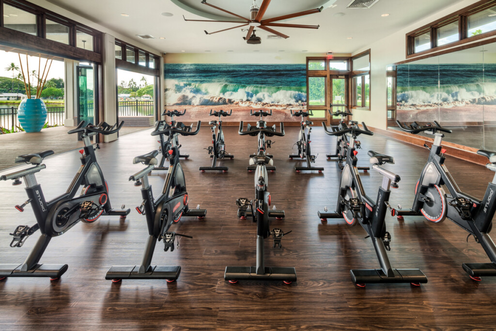 Interior of exercise studio with spinning bikes and walls open to the outside.