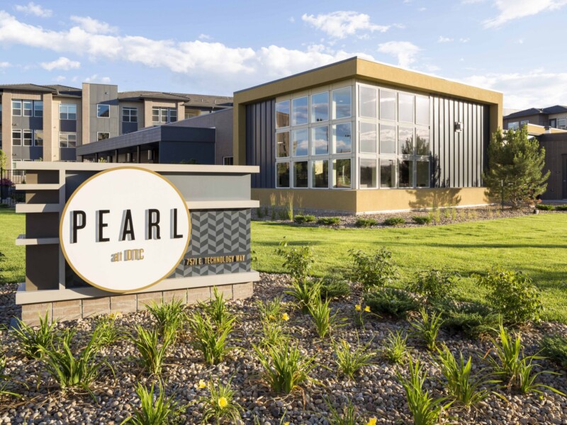 Exterior with sign for Pearl apartments with buildings in the background