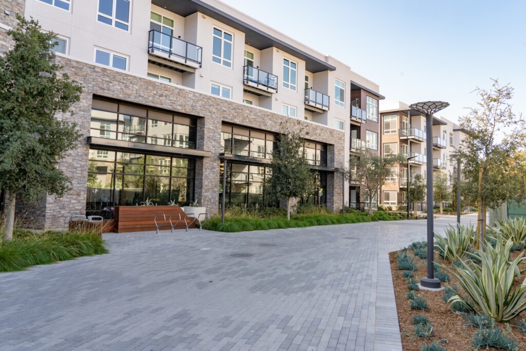 Exterior of modern apartment building with paved walkway in foreground