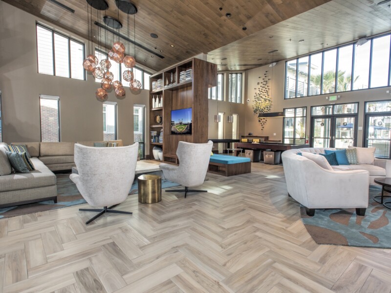 Modern interior with seating areas with couches, high ceilings and pool table