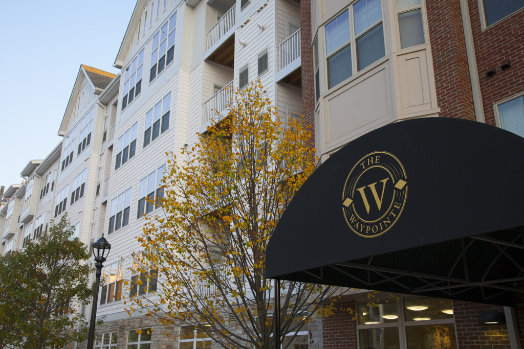 Exterior of apartment complex with awning over entranceway in foreground